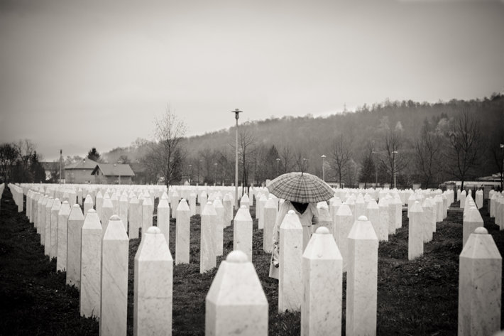 A person walking among graves in Srebrenica, Bosnia, the site of the Srebrenica massacre. matsj // CC BY-NC-ND 2.0